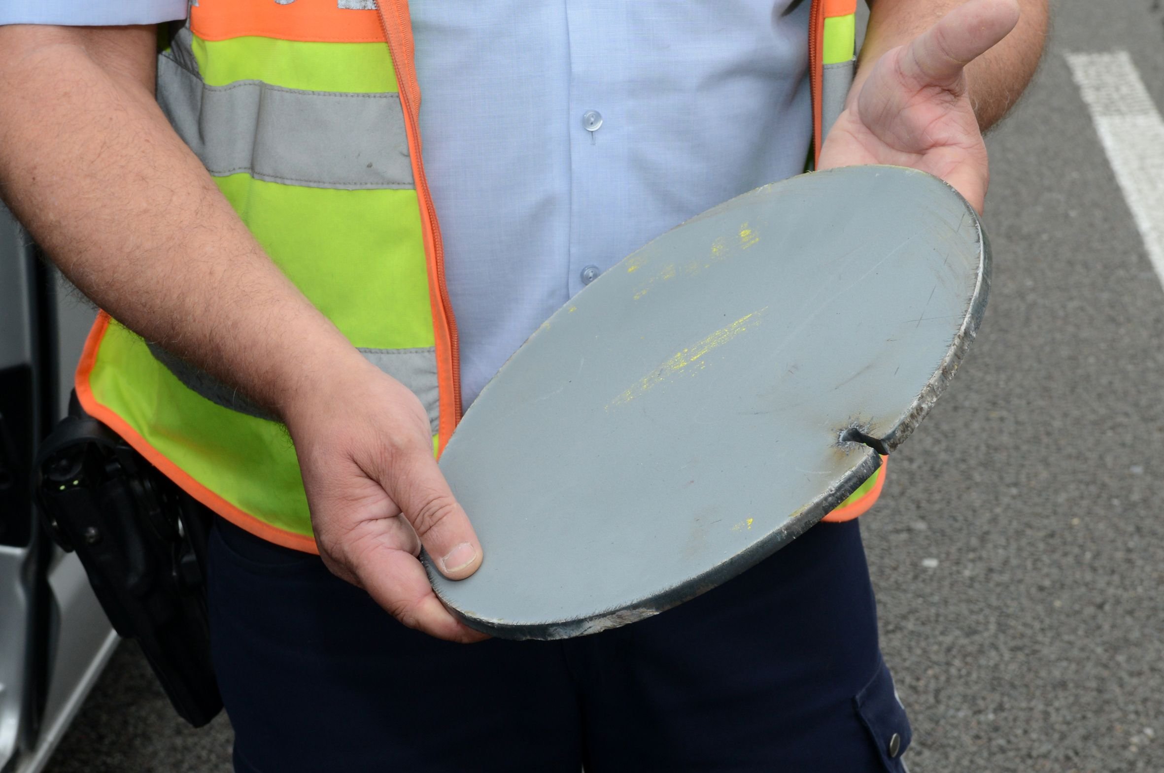 Ein Polizist zeigt auf der Autobahn 31 bei Dorsten (Nordrhein-Westfalen) ein Metallteil. Eine vergleichbare Scheibe hatte auf der Autobahn zu einem tödlichen Unfall geführt.