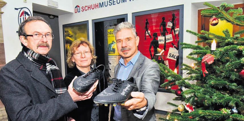 Martin Schmager und Angela Sengewald vom Museum nehmen die Rangnick-Schuhe von Frank Drehmann (von links) entgegen.