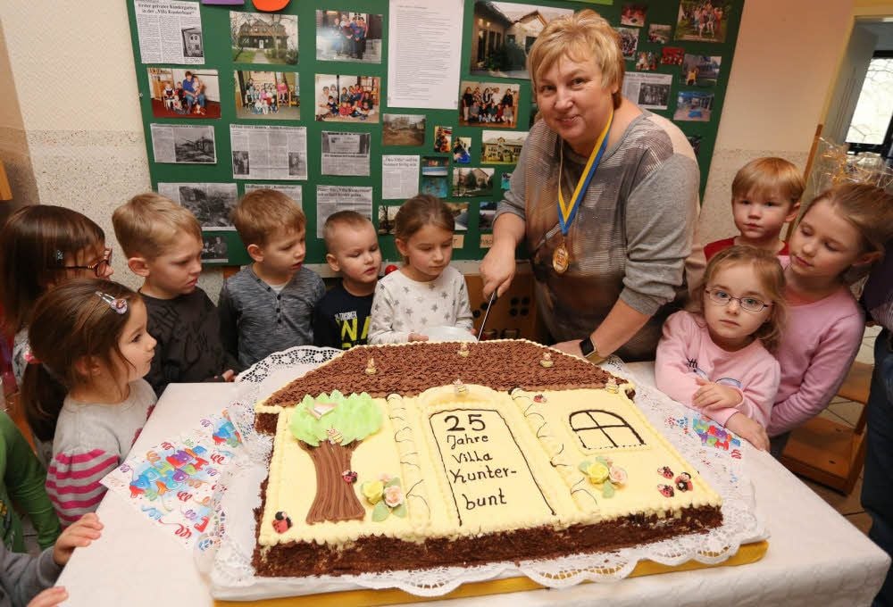 Die Kinder der Kindertagesstätte „Villa Kunterbunt“ schneiden zusammen mit Kita-Leiterin Petra Grabner (4.v.r.) die festliche Torte an.