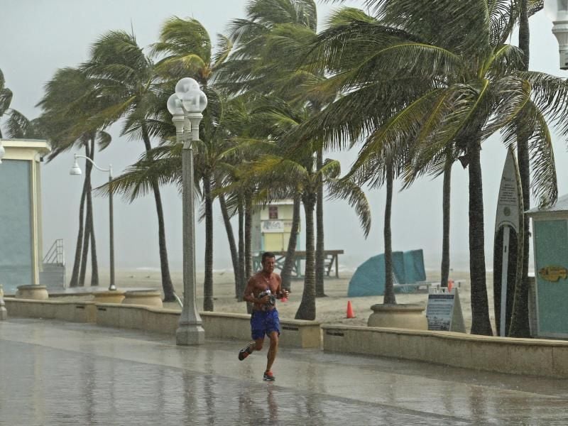 Ein Mann rennt am Hollywood Beach durch den Regen. Foto: David Santiago/Miami Herald/AP
