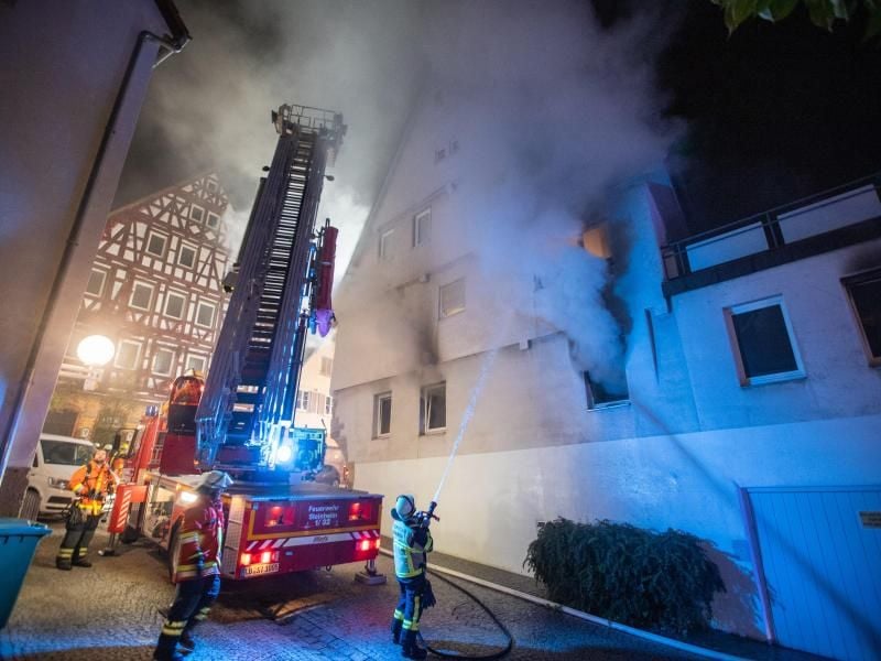 Feuerwehrleute löschen einen Brand in einem Gebäude in der Innenstadt von Marbach. Foto: Simon Adomat/VMD-Images/dpa