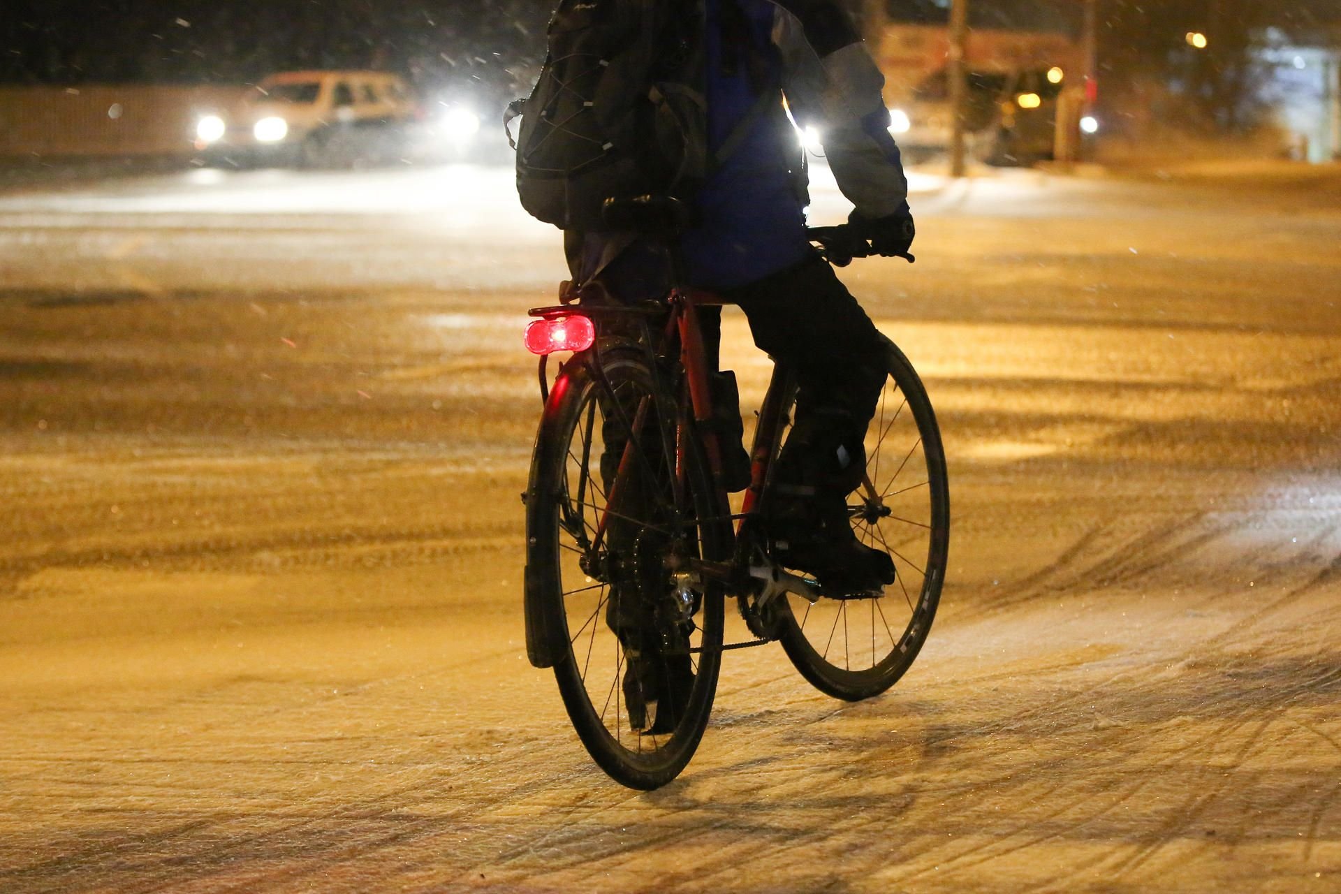 Illustration: Ein Fahrradfahrer kämpft auf glatter Straße mit Schnee und Eis.