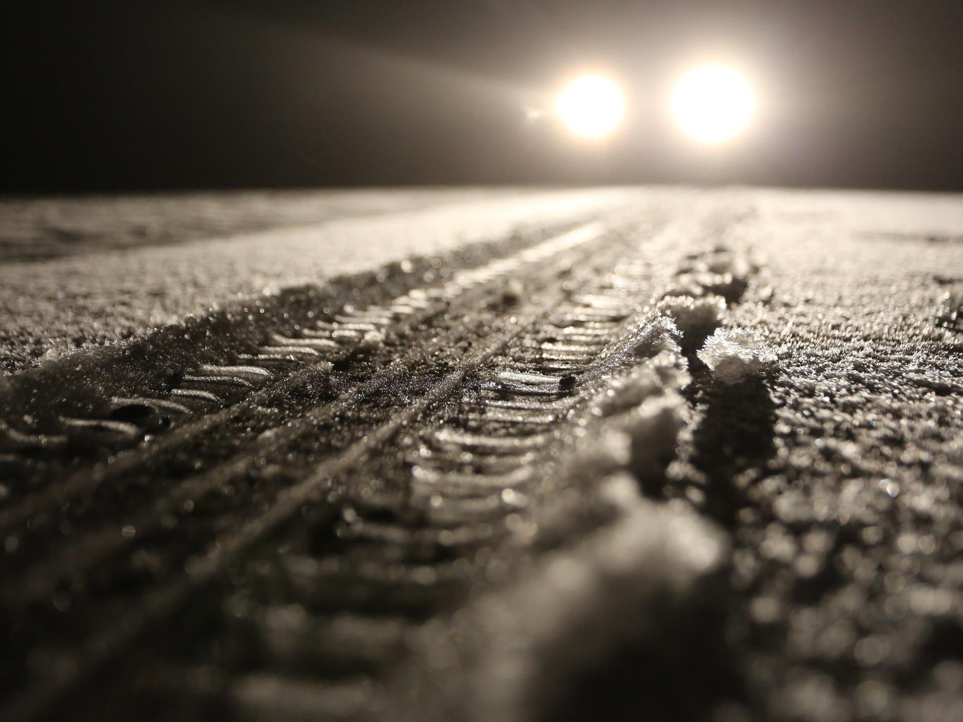 Fahrzeugspuren sind am Donnerstagabend bei Schierke im Schnee zu sehen. Der Brockengipfel lag unter einer dünnen Schneedecke.