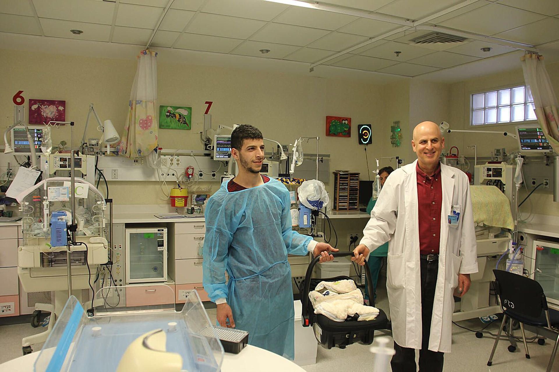Der 22-Jährige Mohammed (l) mit seinem ersten Kind, einem Jungen, und Professor David Mankura vom Hadassah-Krankenhaus in Jerusalem. Nachdem Mohammeds Mutter mit 38 Großmutter geworden ist, hat sie selbst wenige Stunden später Drillinge zur Welt gebracht.
