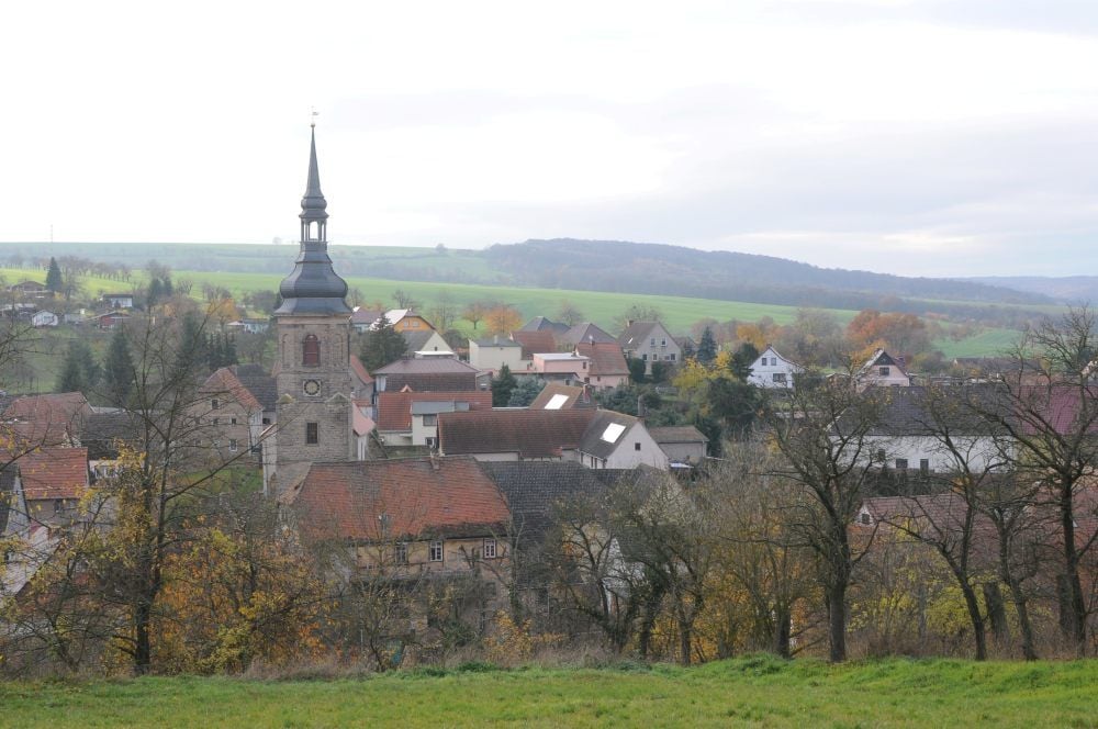 Blick ins Tal hinein auf Bucha mit der charakteristischen Dorfkirche St. Cecilien-Kilian im Vordergrund. Das Gotteshaus wurde ab 2010 unter tatkräftiger Mithilfe der Einwohner saniert.