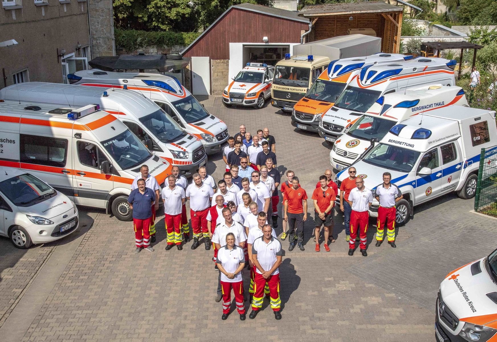 Gruppenbild mit Fahrzeugen: Angehörige des DRK-Kreisverbands Quedlinburg/Halberstadt mit Kameraden vom Rettungsdienst, Bergrettung, Katastrophenschutz und Wasserwacht