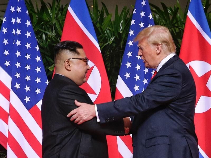 Donald Trump (r) und der Machthaber von Nordkorea Kim Jong Un (l) geben sich die Hand. Foto: Kevin Lim/The Straits Times