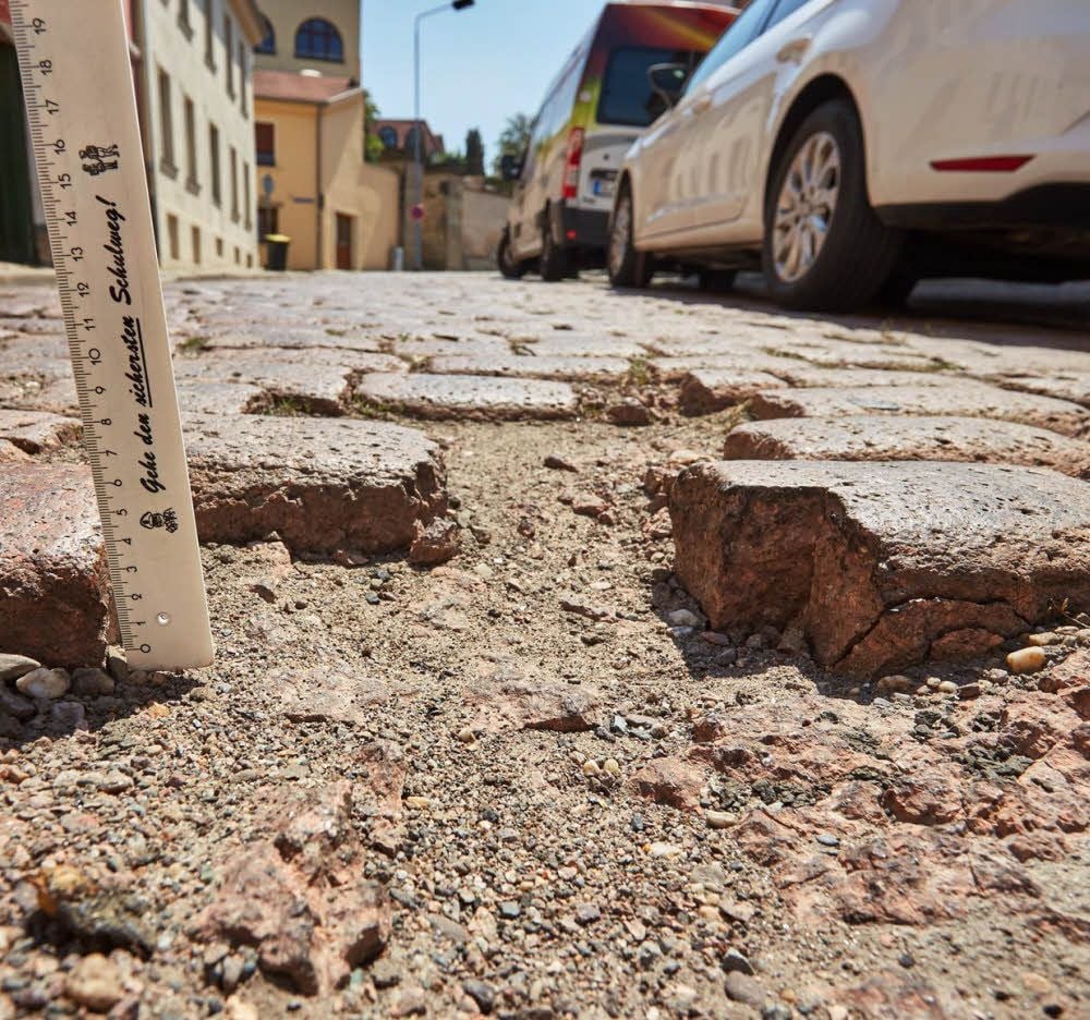 Das bröckelnde Pflaster hat auf dem Kugelweg in Bernburg tiefe Löcher hinterlassen.