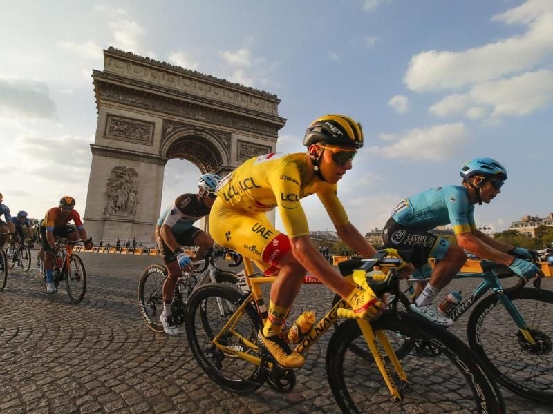 Der Slowene und Gesamtsieger Tadej Pogacar (M), der das gelbe Trikot des Gesamtführenden trägt, fährt am Arc de Triomphe vorbei. Foto: Christophe Ena/AP/dpa