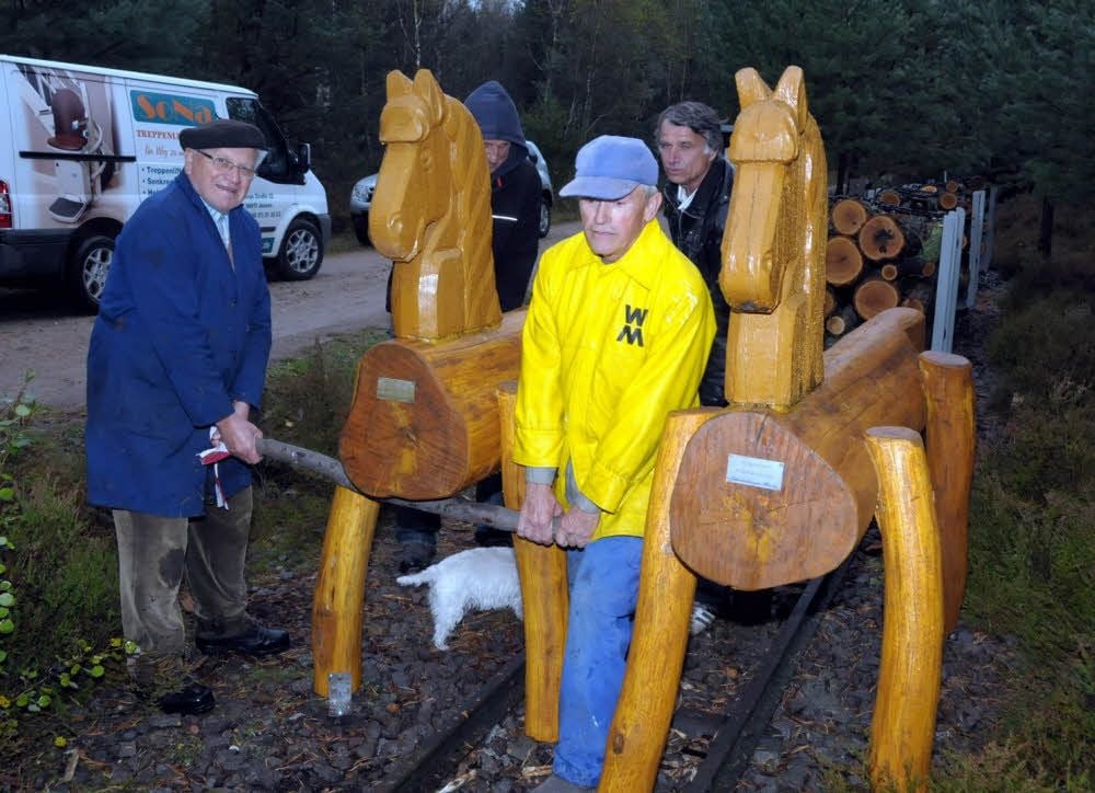 Erhard Fritzsche und Günter Nickchen (vorn) stellen mit Helfern vom Verein eins der neuen Pferde auf.