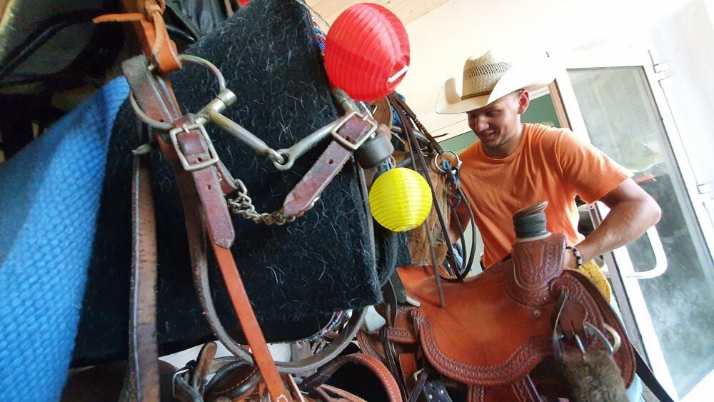 Sebastian Wiechardt in seiner Sattelkammer. Westernsattel sind mit ihrem Horn, dem Knauf vorn, gut von anderen Sätteln zu unterscheiden.