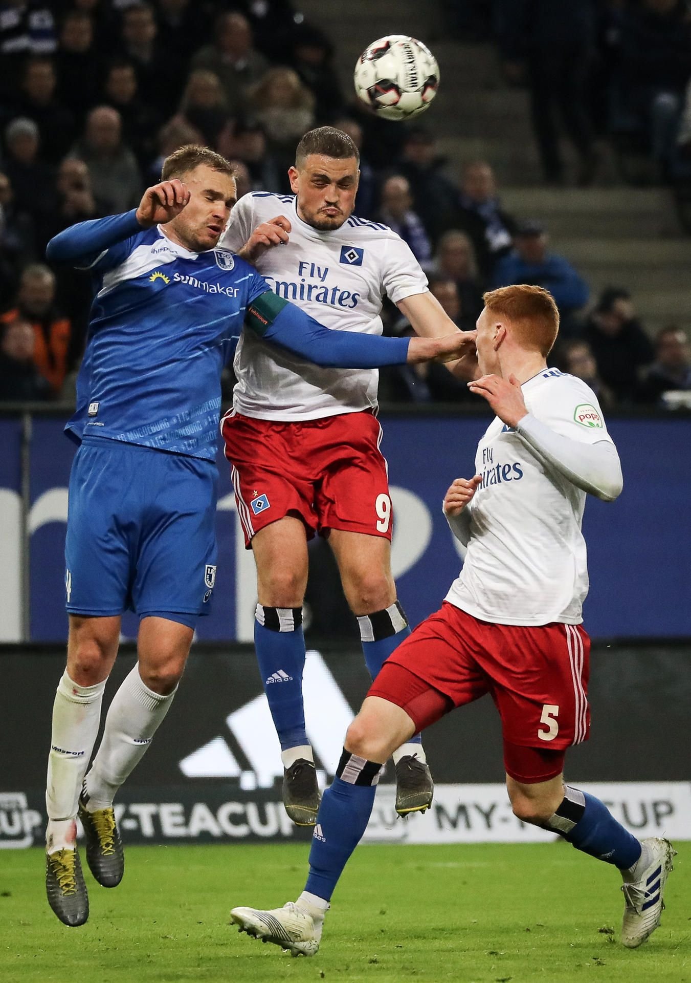 Magdeburgs Jan Kirchhoff (l-r) und Hamburgs Kyriakos Papadopoulos und David Bates kämpfen um den Ball.