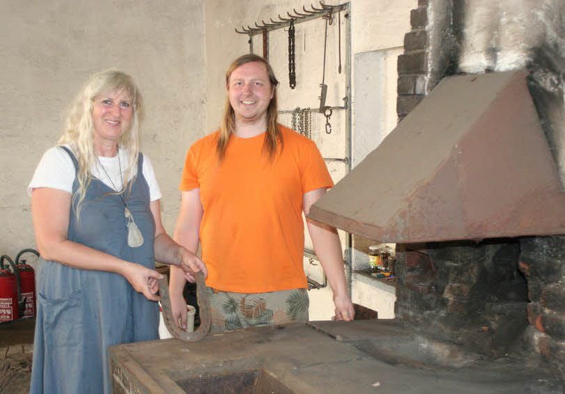 Mutter Anna und Sohn Kurt Ostwald an der Feuerstelle der alten Schmiede, die der Verein zu Seminarraum und Museum umgestalten möchte.