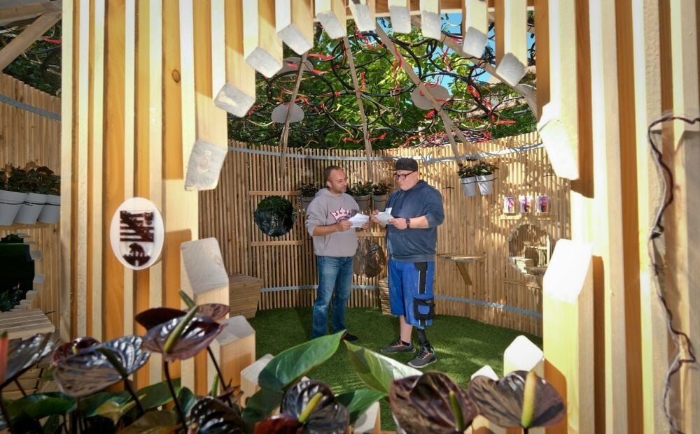 Mitarbeiter Andreas Zippler (links) und Marcel Krahl unterhalten sich im Sachsen-Anhalt-Pavillon über die ausgelegten Flyer.