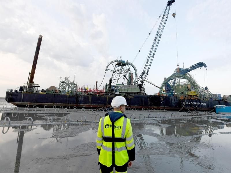 Das Endstück eines Seekabels wird an Land gezogen. Foto: Carsten Rehder/Archivbild