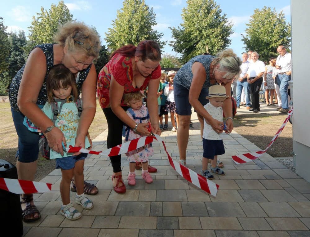 Der Weg in die neue Kindertagesstätte „Marienkäfer“ in Klöden wird durch drei Scherenschnitte freigegeben.