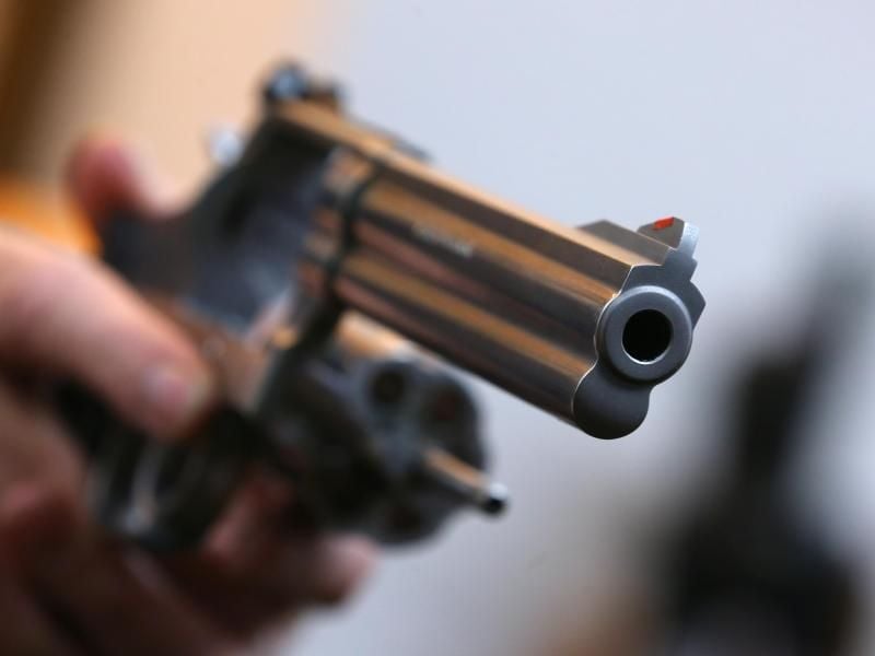 Ein Mann hält in einem Waffengeschäft einen Revolver des Herstellers Smith & Wesson. Foto: Karl-Josef Hildenbrand/Archiv