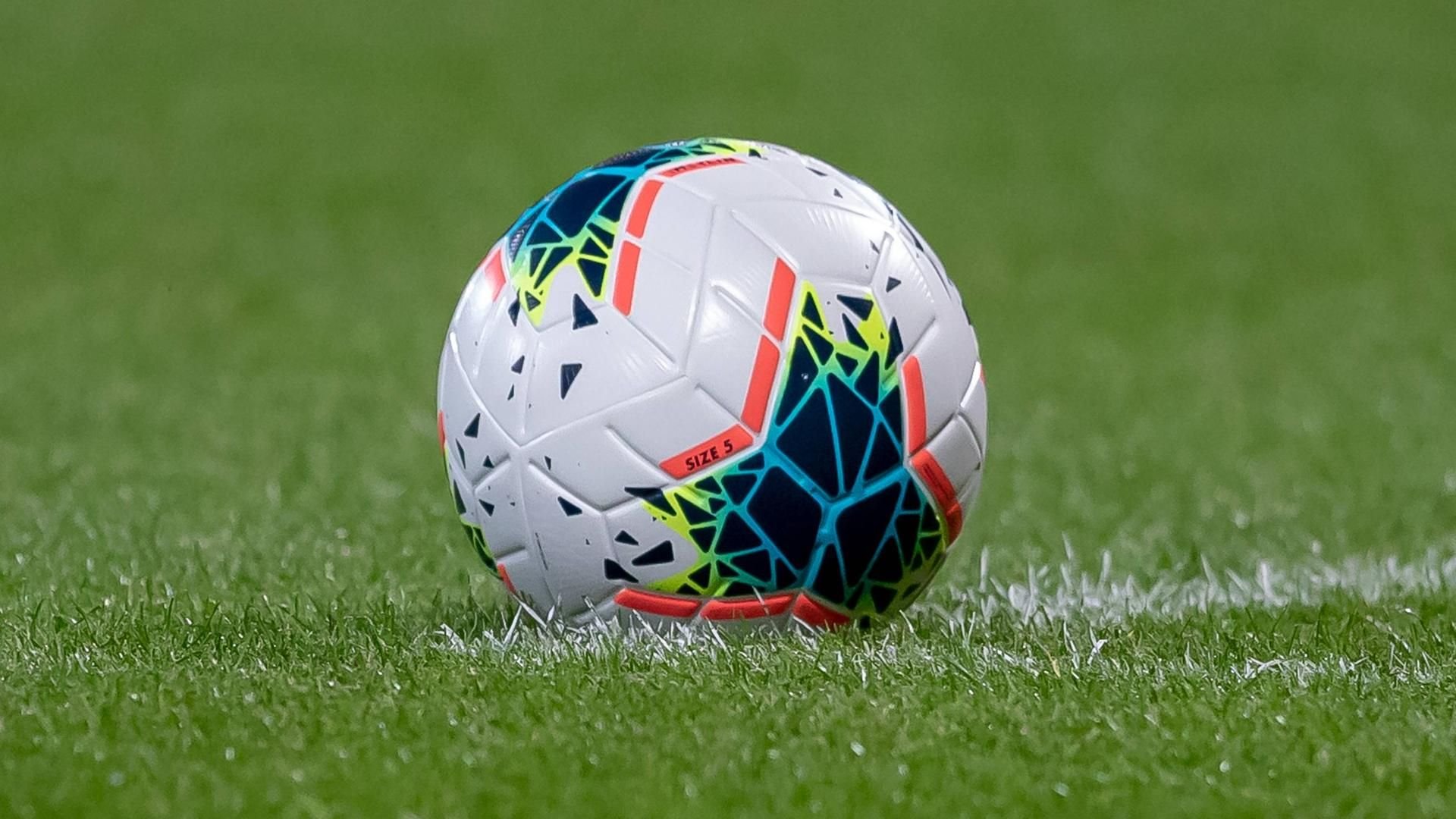 Ein Fußball liegt auf Spielfeld.