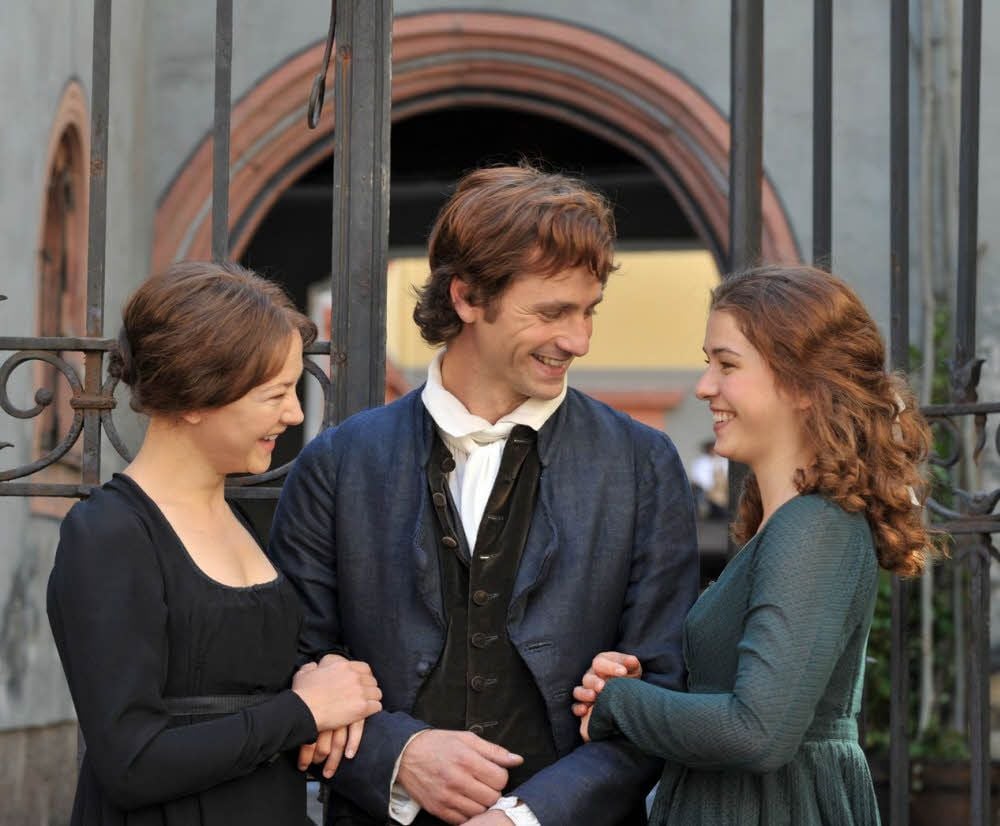 Welche soll es sein? Schiller (Florian Stetter) muss sich im Kinofilm „Geliebte Schwestern“ (2014) zwischen den Schwestern Caroline (Hannah Herzsprung, links) und Charlotte Lengefeld (Henriette Confurius) entscheiden.