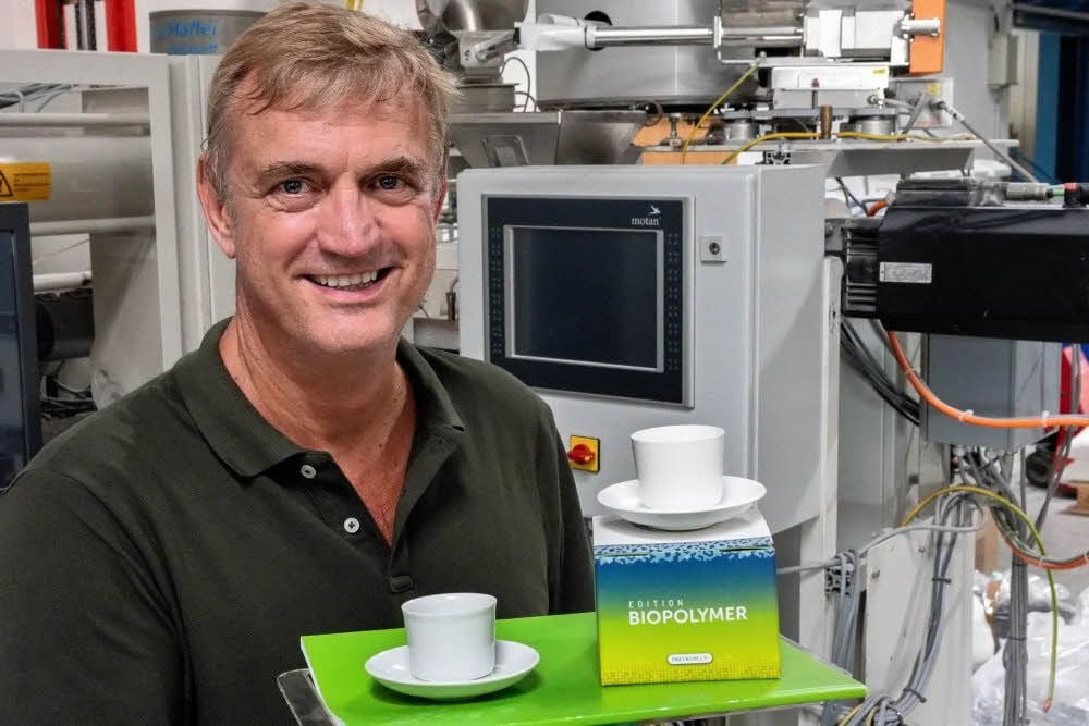 Peter Putsch präsentiert links die Originaltasse der Bauhaus-Künstlerin aus Porzellan und rechts die Bio-Tasse, die in Merseburg hergestellt wird.