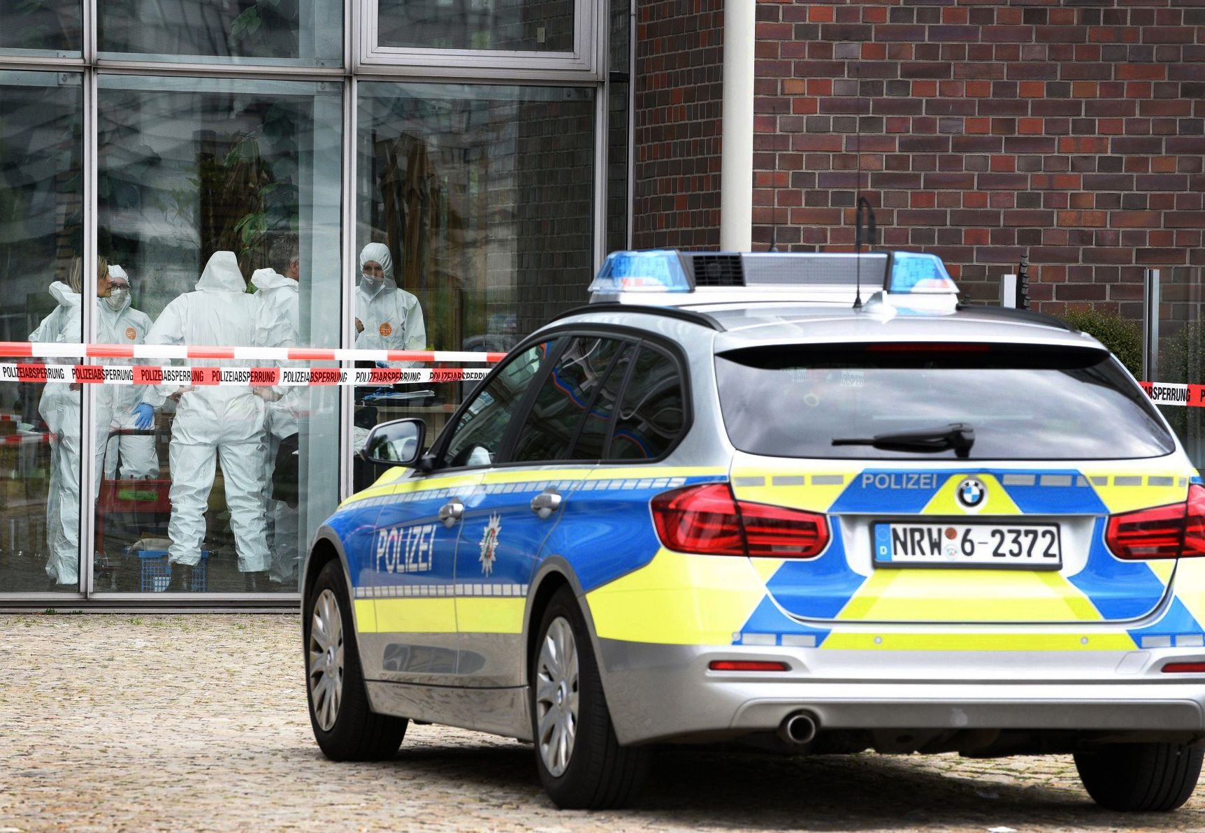 Polizeibeamte stehen am 03.05.2017 in Duisburg (Nordrhein-Westfalen) hinter der Glascheibe in einem Cafe.