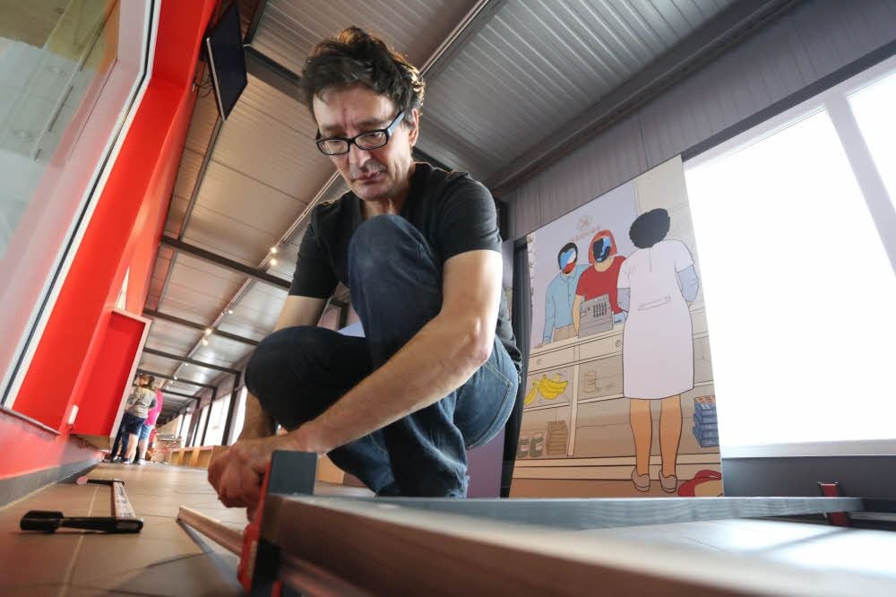 Uwe Dittrich bereitet mit viel Sorgfalt den Rahmen für eine Ausstellungswand vor.