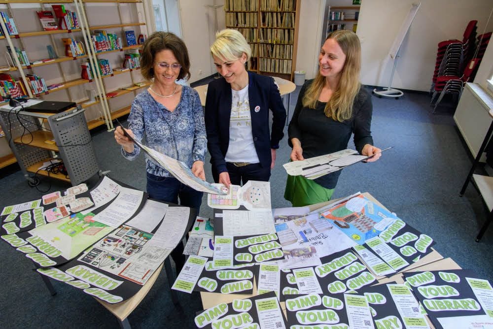 Sabine Matzner (l.) und Antje Key (r.) von der Stadt- und Kinderbibliothek sehen sich mit Citymanagerin Sylvia Kühl die Schülerarbeiten an.