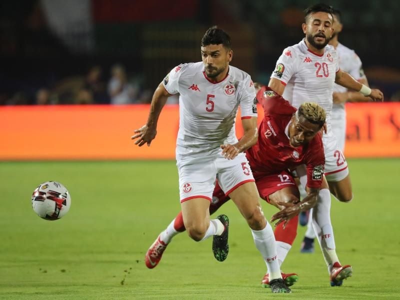 Madagaskars Lalaina Nomenjanahary (M) und Tunesiens Oussama Haddadi (l) kämpfen um den Ball. Foto: Gehad Hamdy