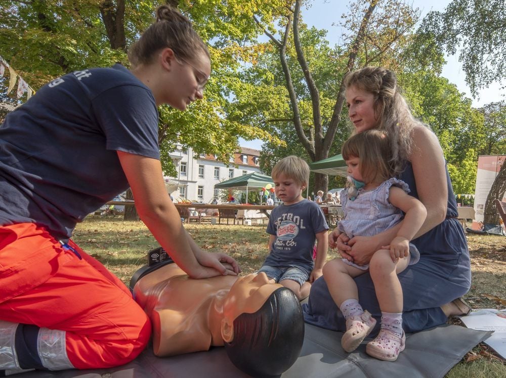 Marlene Witruk (l.) von der Wasserwacht zeigt Carolin Brandt und ihren Kindern Roxana Rose und Roman-Marijus, wie reanimiert wird.