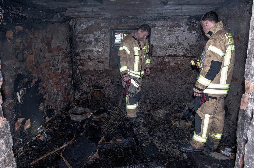 Feuerwehrleute kontrollieren nach dem verheerenden Brand den Keller eines Mehrfamilienhauses. Hier war das Feuer ausgebrochen.