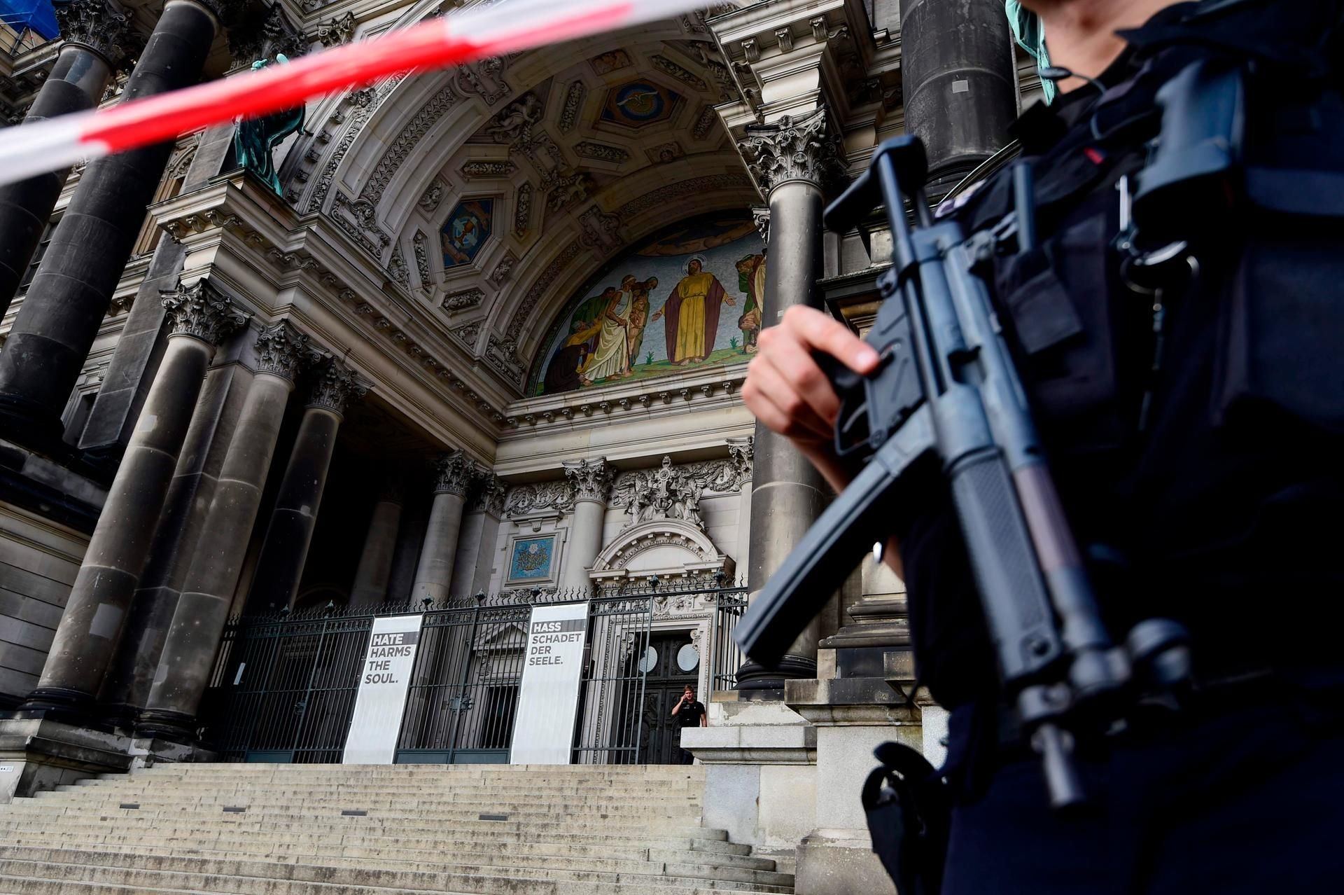Ein bewaffneter Polizist steht vor dem Berliner Dom.