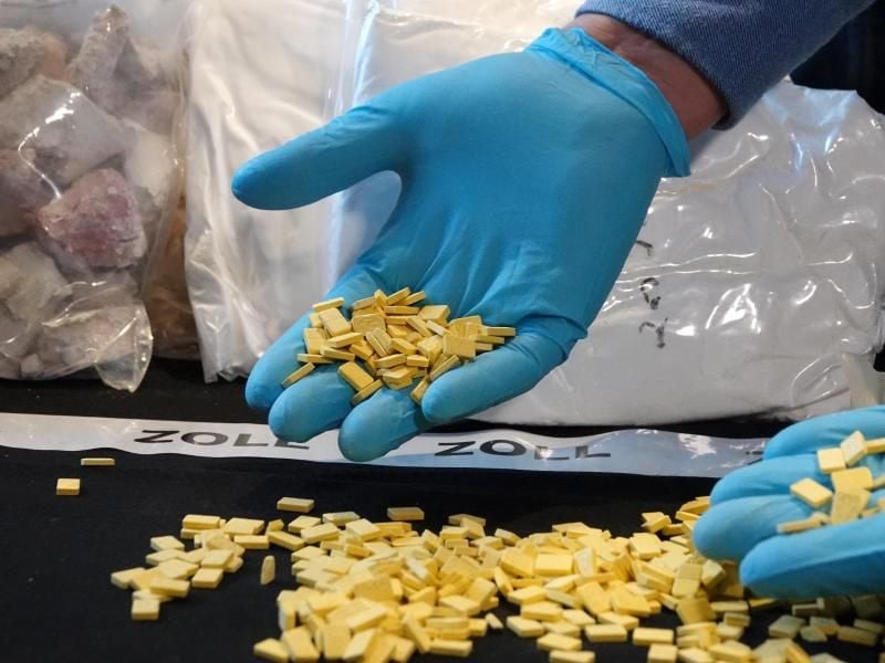 Ein Zollbeamter zeigt sichergestellte Ecstasy-Tabletten im Zollfahndungsamt. Foto: Hannah Wagner