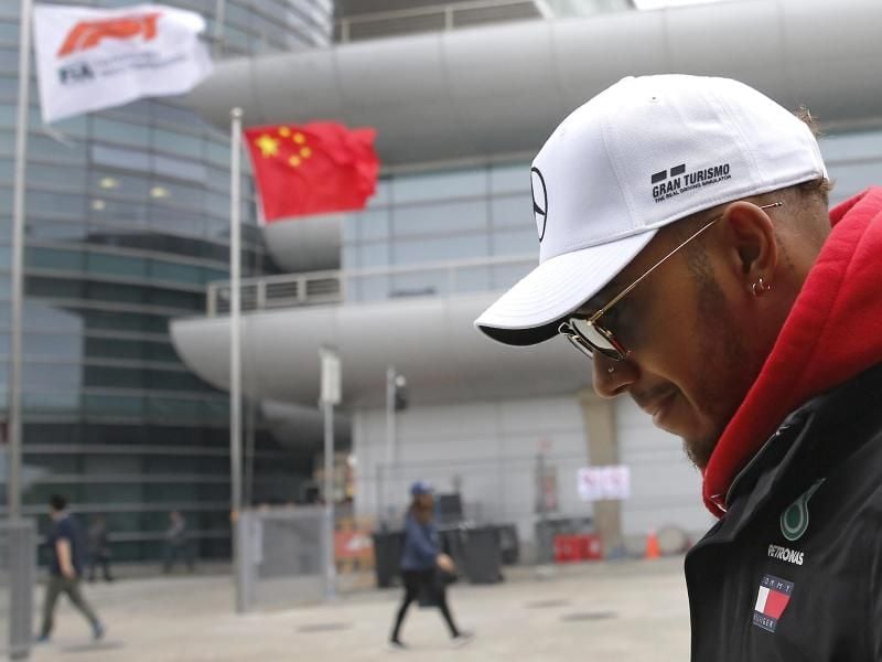 Lewis Hamilton geht im Vorfeld zum Großen Preis von China durch das Fahrerlager. Der Brite will sich mehr zurückhalten. Foto: Andy Wong/AP