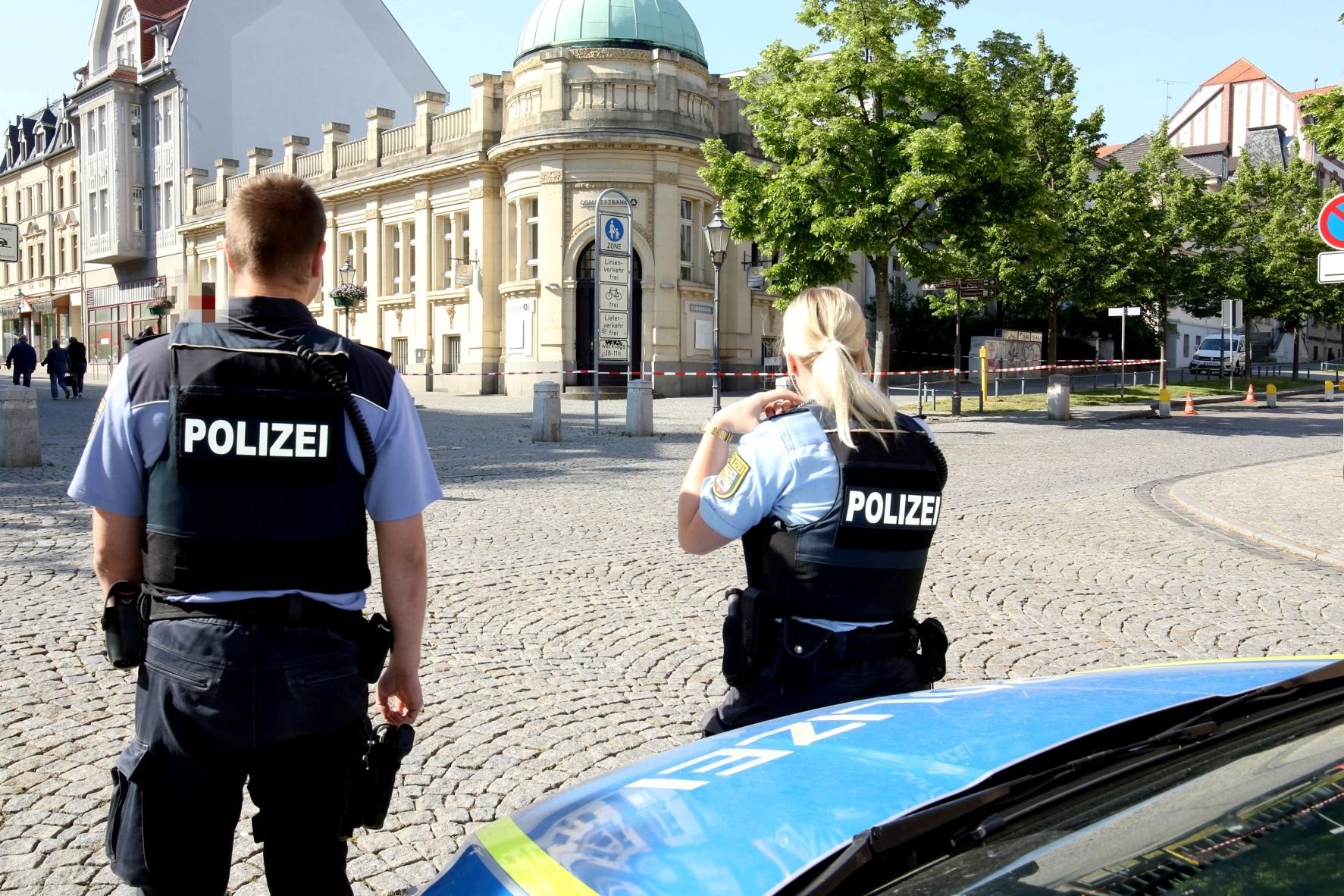 Polizeibeamte stehen vor der abgesperrten Filiale der Commerzbank in Bernburg.
