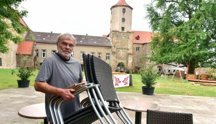 Gottfried Jahn stellt die Stühle auf der Terrasse auf.