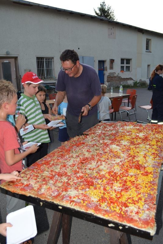 Die Pizza von Pfarrer Armin Pra ist bei den Mitgliedern der Kinder-Feuerwehr heiß begehrt.