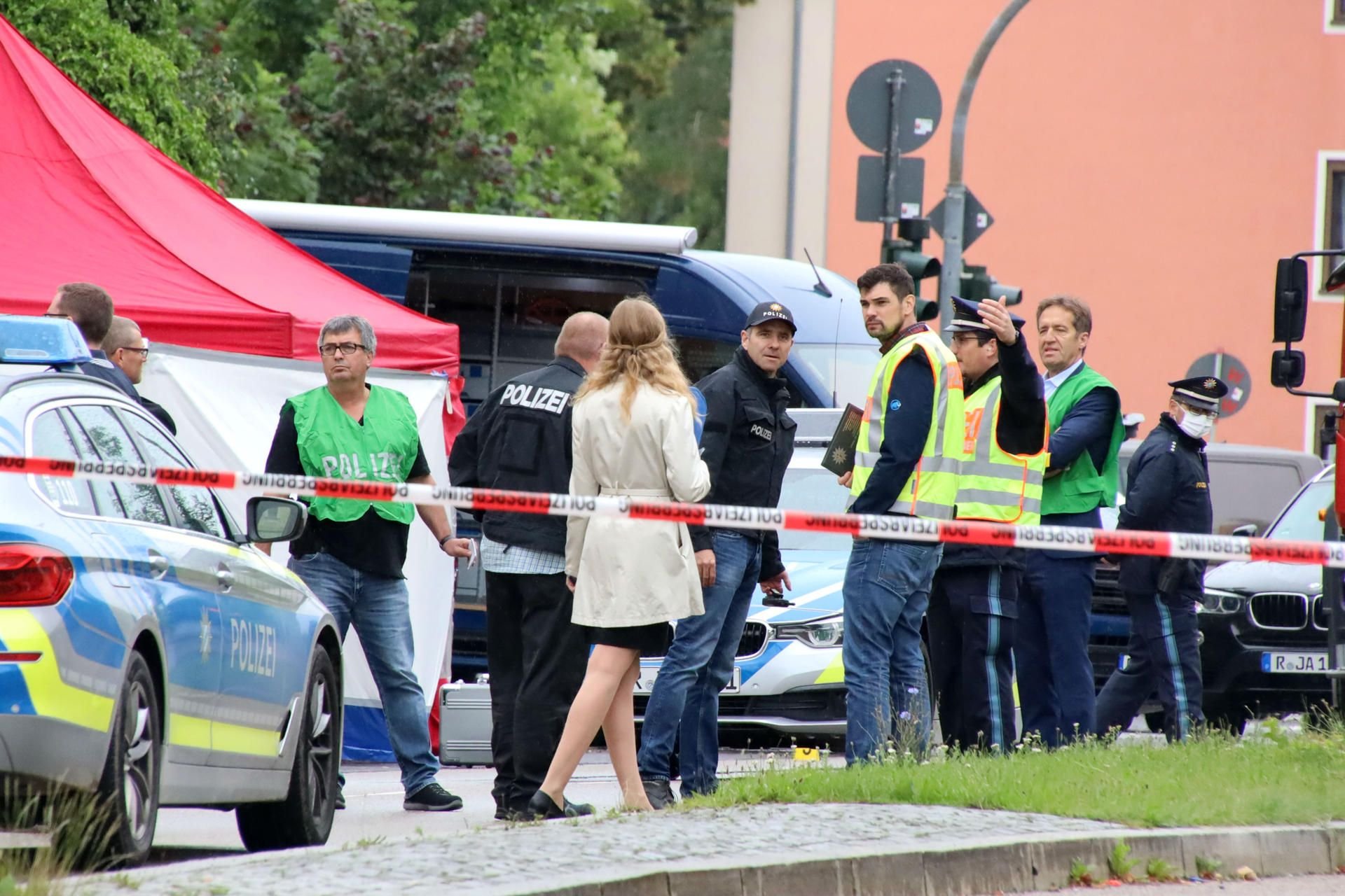 Polizisten stehen in Regensburg an einem Tatort, an dem zuvor ein Mann auf der Straße erschossen wurde.