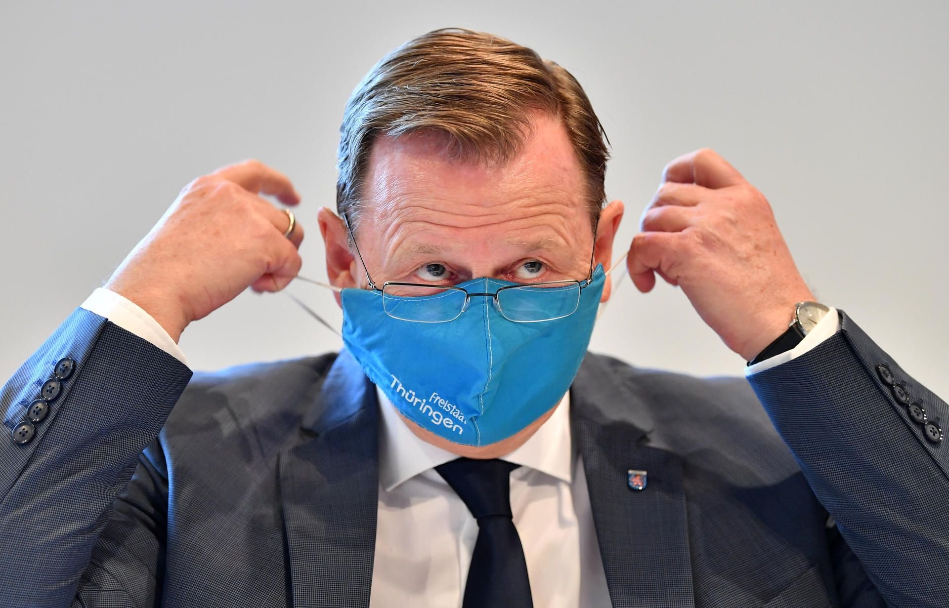 Bodo Ramelow (Die Linke), Ministerpräsident von Thüringen, hantiert mit einer Nase-Mundschutz-Maske.