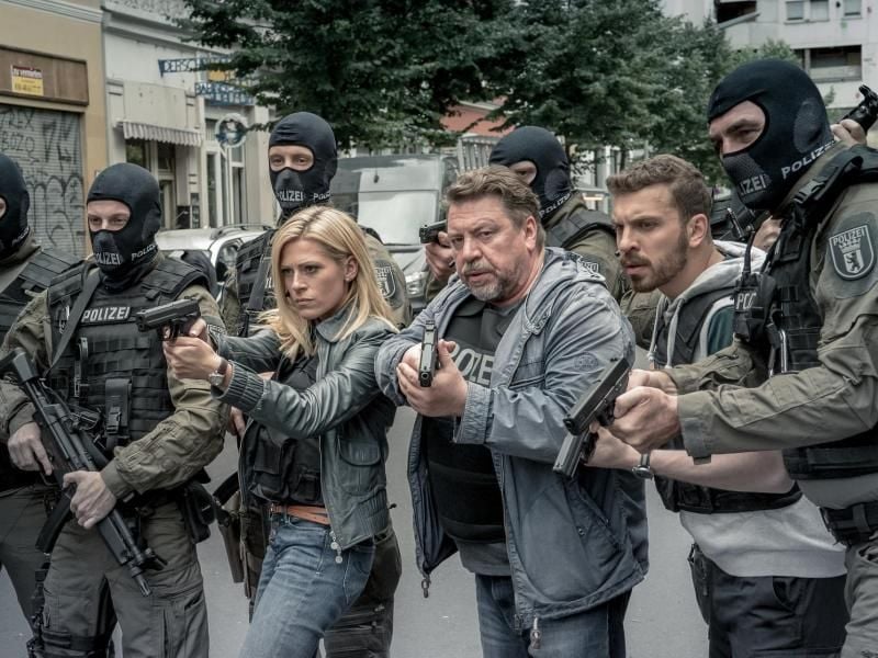 Lola Karras (Nele Kiper), Fredo Schulz (Armin Rohde) und Milan Filipovic (Edin Hasanovic) stehen mit gezogenen Waffen zwischen SEK-Beamten (l-r). Foto: Nik Konietzny/ZDF/dpa