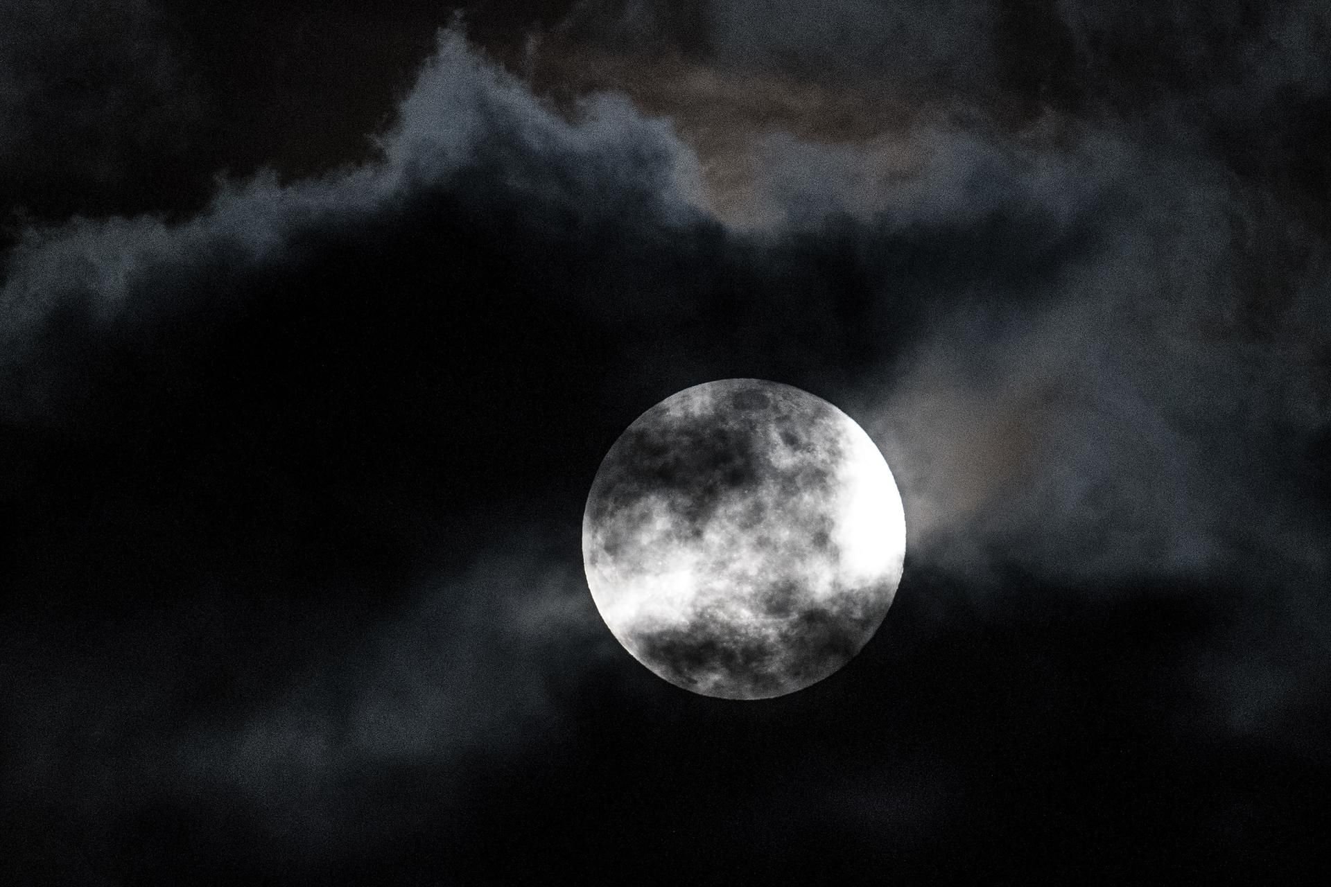 Wolken ziehen an einem besonders groß erscheinenden Vollmond vorüber.
