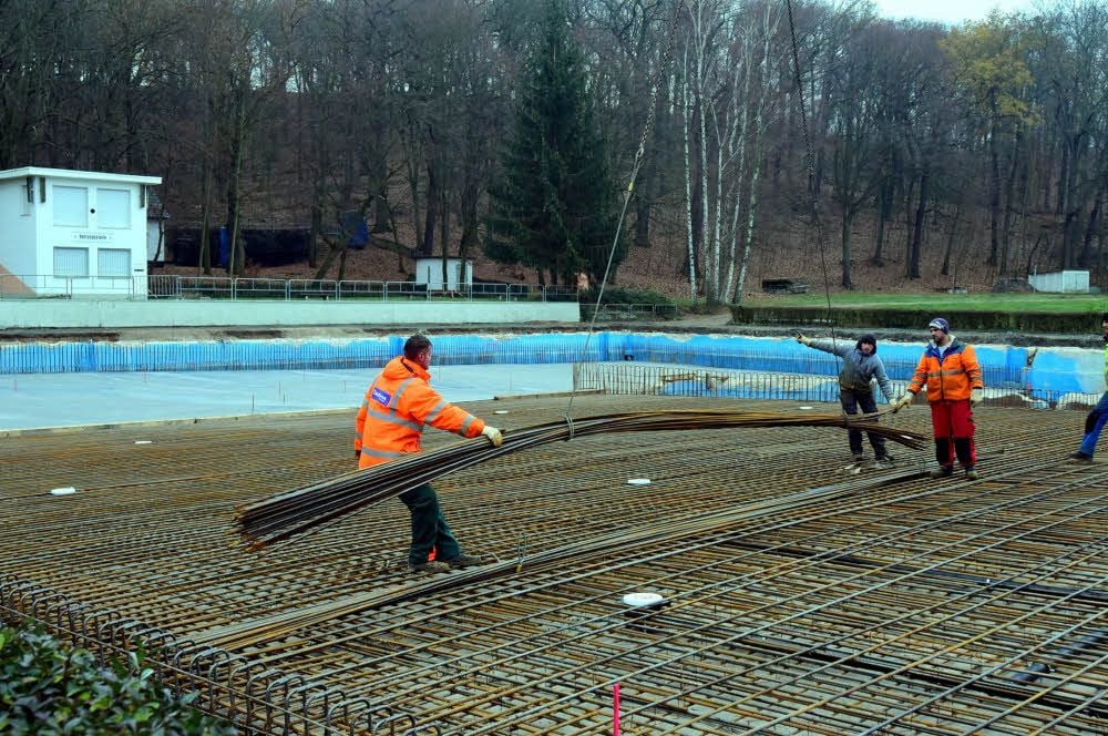 Per Kran „fliegen“ neue Bewehrungsstäbe in das Becken.