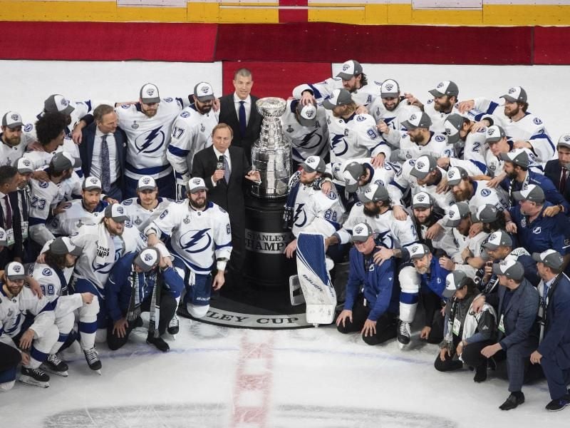 Die Spieler von Tampa Bay Lightning posieren mit NHL-Commissioner Gary Bettman (M) mit dem Stanley Cups. Foto: Jason Franson/The Canadian Press/AP/dpa