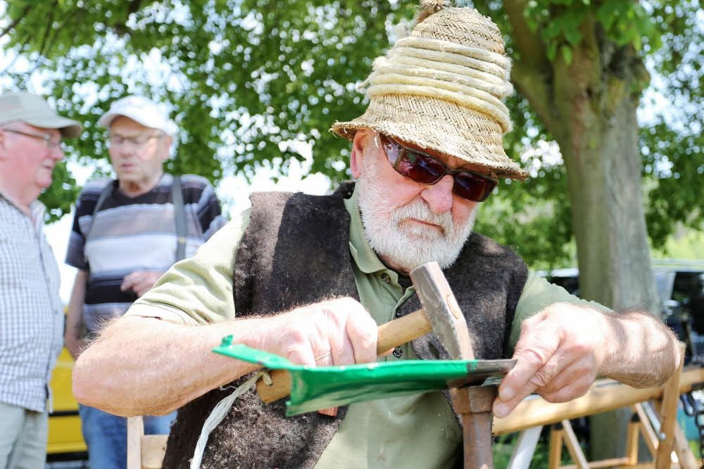 Armin Tegeler aus der Leinemühle dengelt vor den Augen der Besucher ein Sensenblatt.