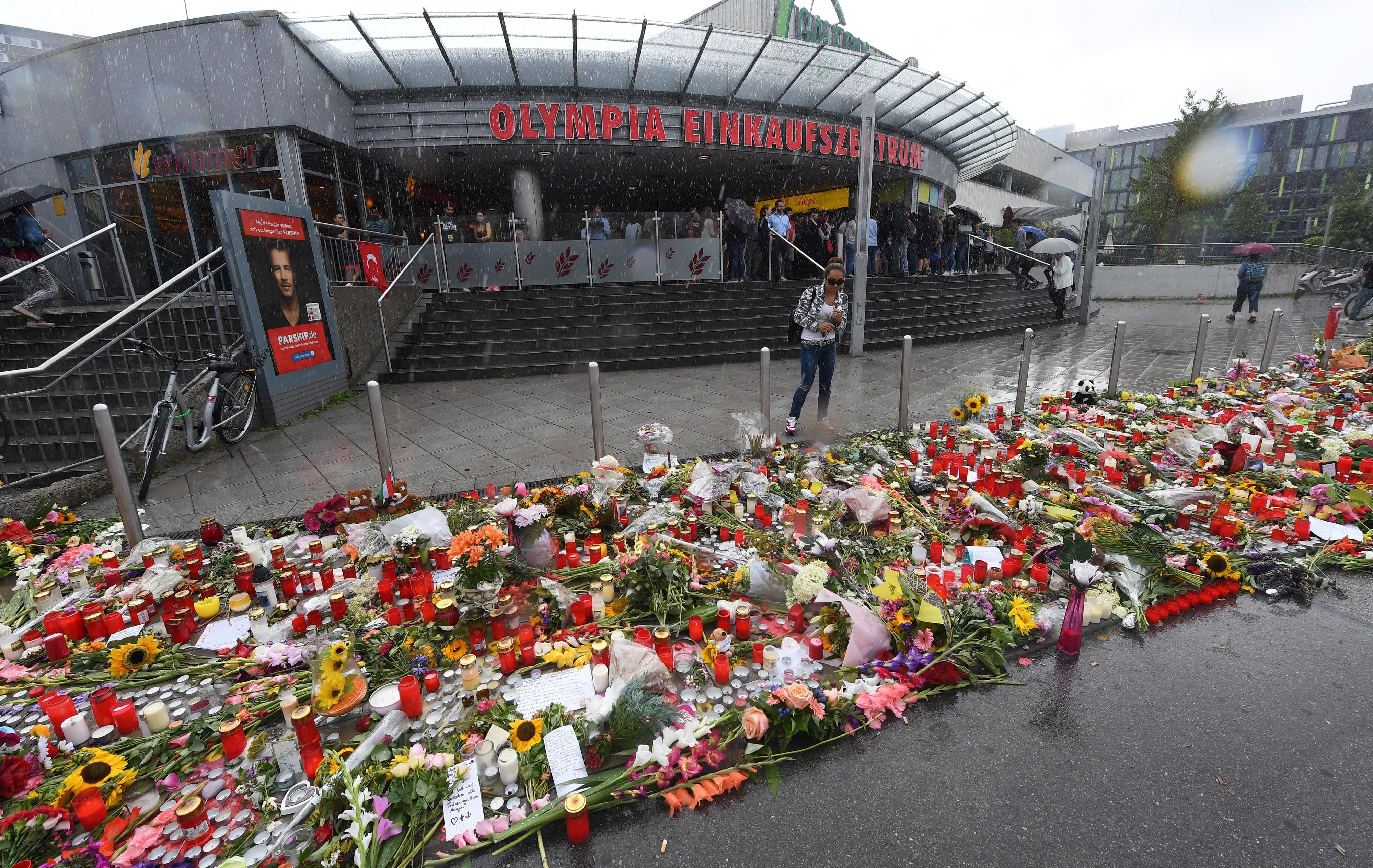 Blumen vor dem Haupteingang des Olympia-Einkaufszentrums in München, wo vor gut einer Woche ein Attentäter neun Menschen und sich selbst getötet hat.