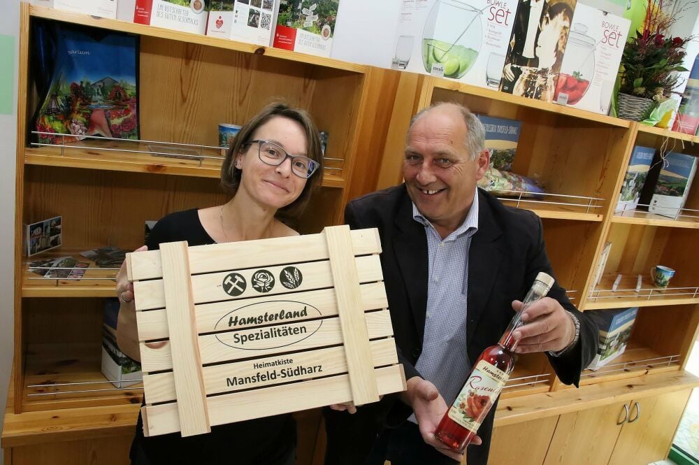 Sangerhausen: Janine Meyer und Jörg Brockmann mit der „Heimatkiste“ und dem Rosenlikör im neuen Laden.