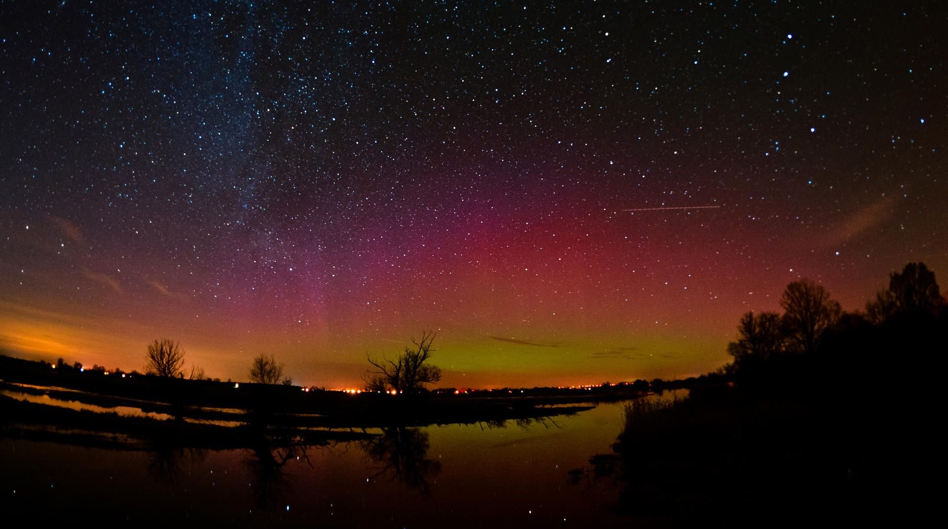 Ein Polarlicht leuchtet am Nachthimmel über der Gülper Havel, einem Nebenfluss der Havel, in Gülpe (Brandenburg).