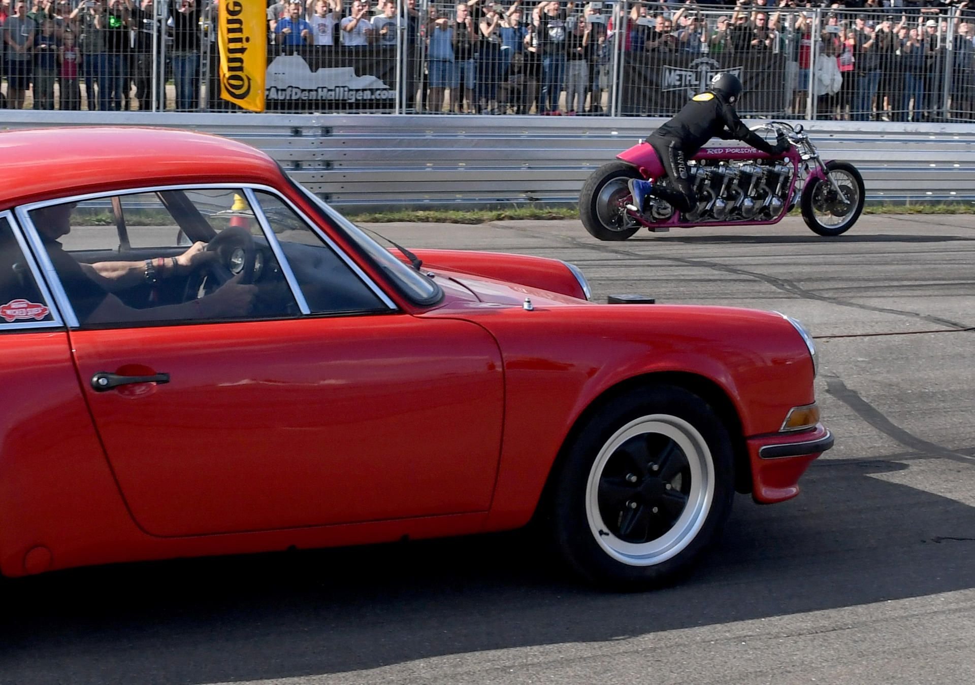 Rötger "Brösel" Feldmann zieht mit seinem "Red Porsche Killer" Dragster an Holger "Holgi" Henze in seinem Porsche vorbei.