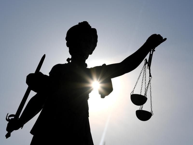 Die Statue der Justitia steht mit einer Waage und einem Schwert in der Hand. Foto: Arne Dedert/dpa/Archivbild