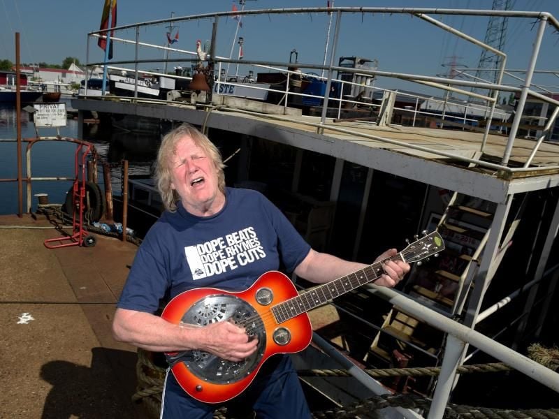 Der Musiker Gunter Gabriel spielt im Hafen vor seinem Hausboot Gitarre. Foto: Axel Heimken/Archiv