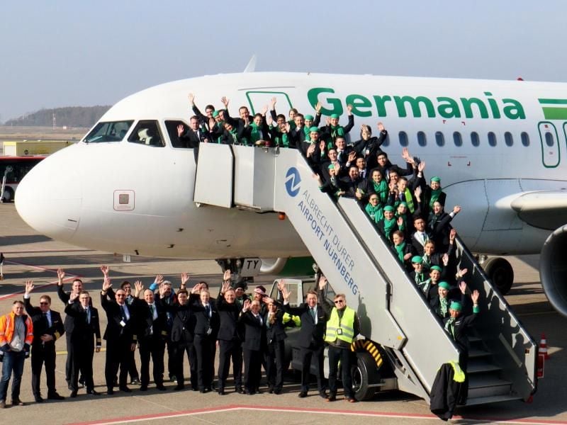 Mitarbeiterinnen und Mitarbeiter der insolventen Fluggesellschaft Germania haben sich für ein Abschiedsfoto am Airport Nürnberg zusammengefunden. Foto: Christian Albrecht/Airport Nürnberg/dpa